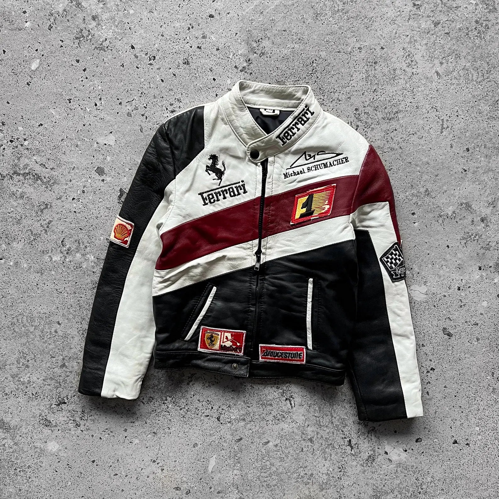 Veste en cuir tricolore noir blanc bordeaux, col montant, fermeture zippée, patchs et broderies style course auto